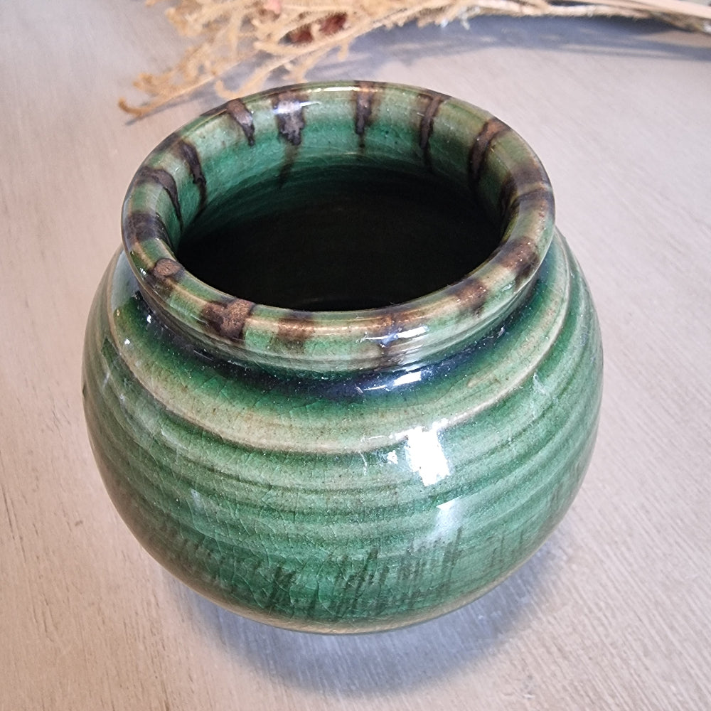 Vintage round green glazed pottery vase with drip glaze and small feet.