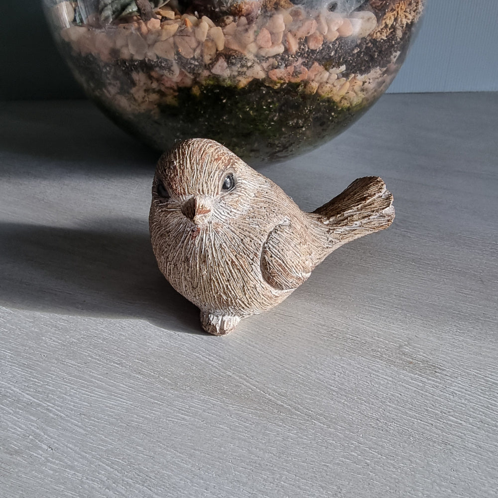 Rustic ceramic bird ornament with natural wood-tone finish.