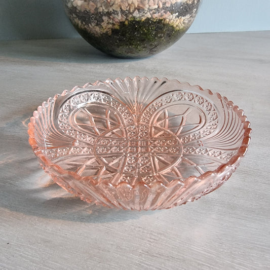 Vintage pink Depression glass bowl with scalloped edge and pressed pattern.