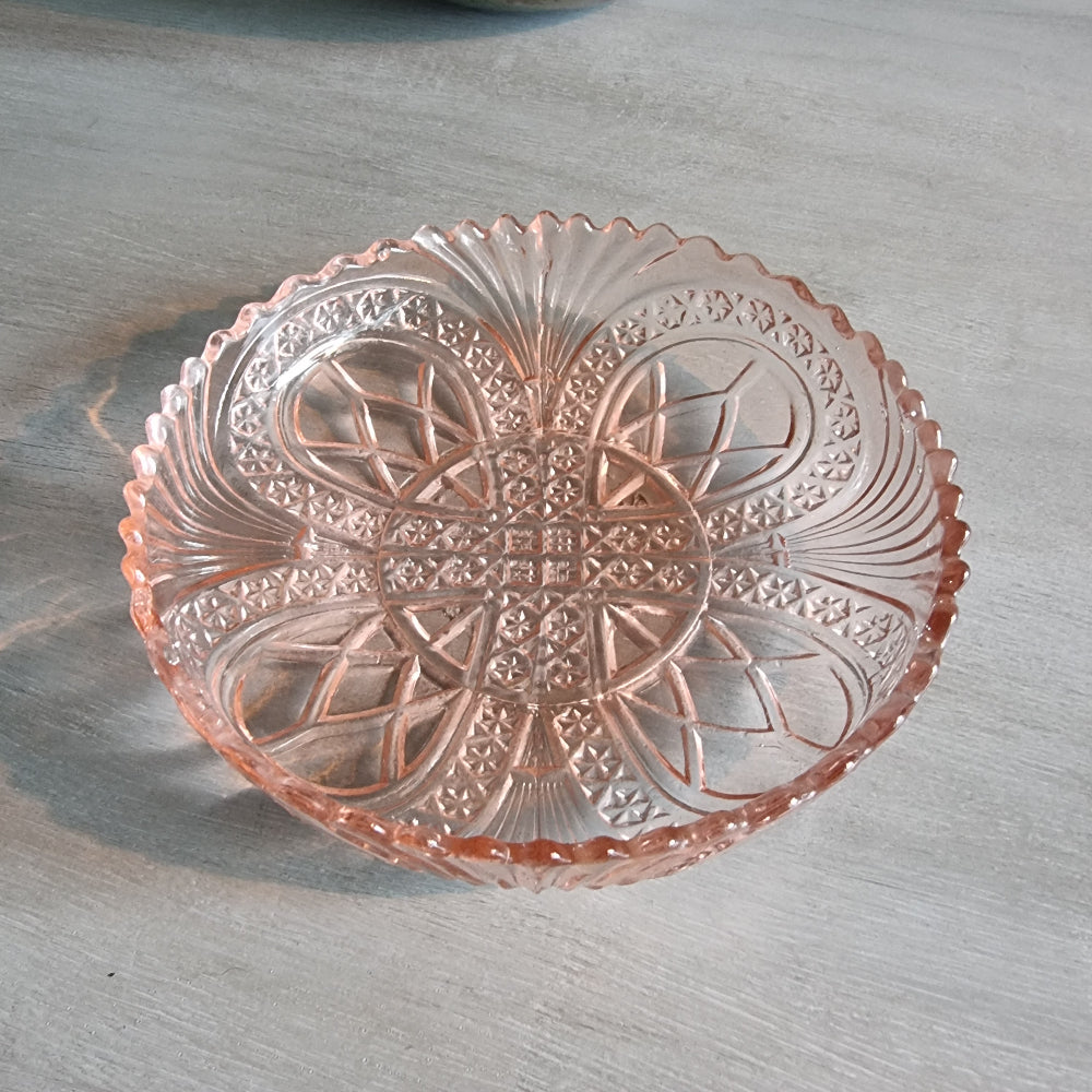 Vintage pink Depression glass bowl with scalloped edge and pressed pattern.