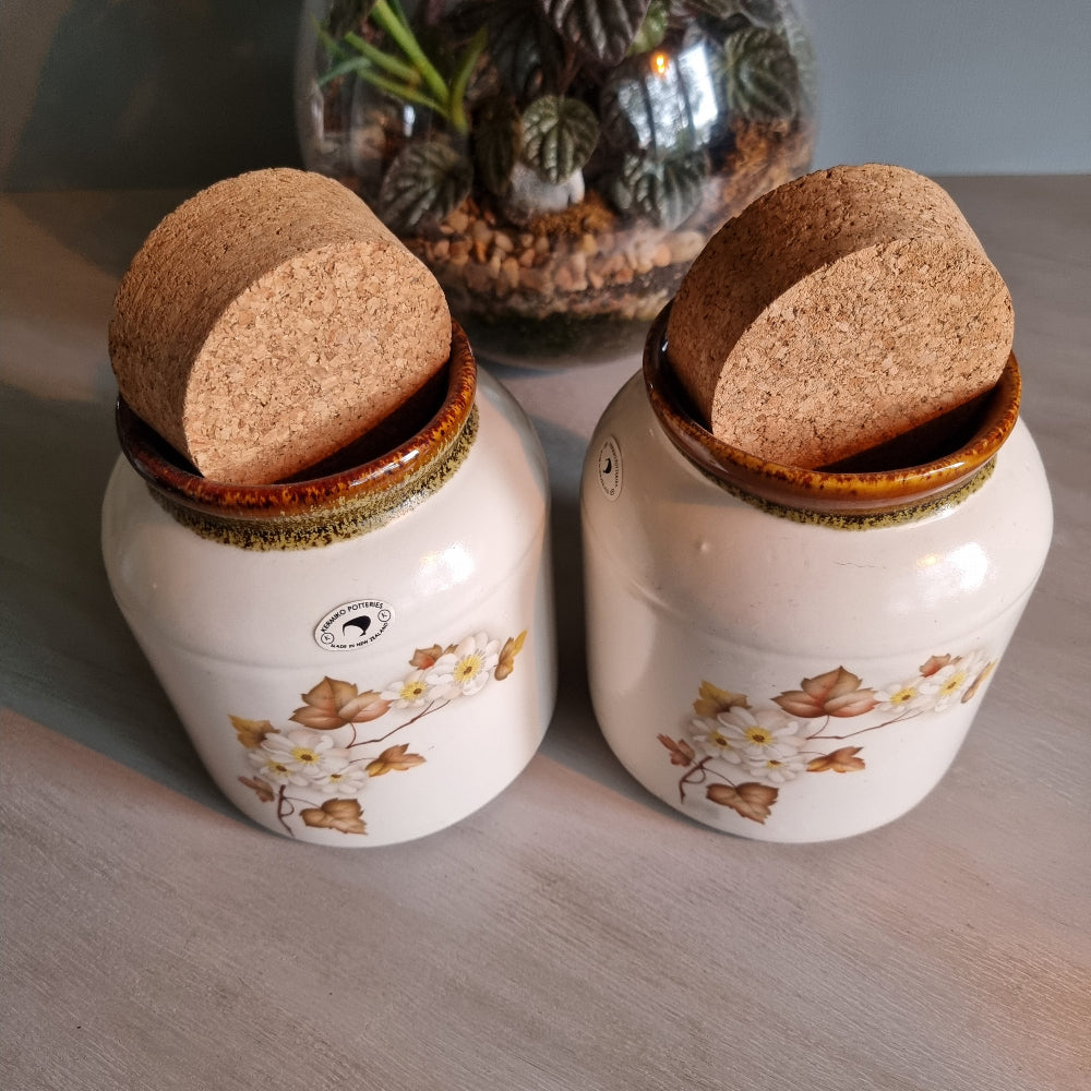 Pair of Kermiko Potteries floral ceramic jars with cork lids.