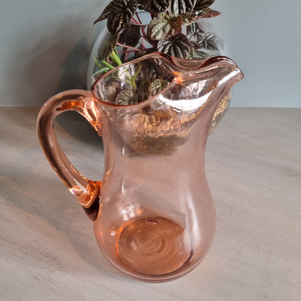 Vintage pink glass jug with curved handle and soft blush tint.