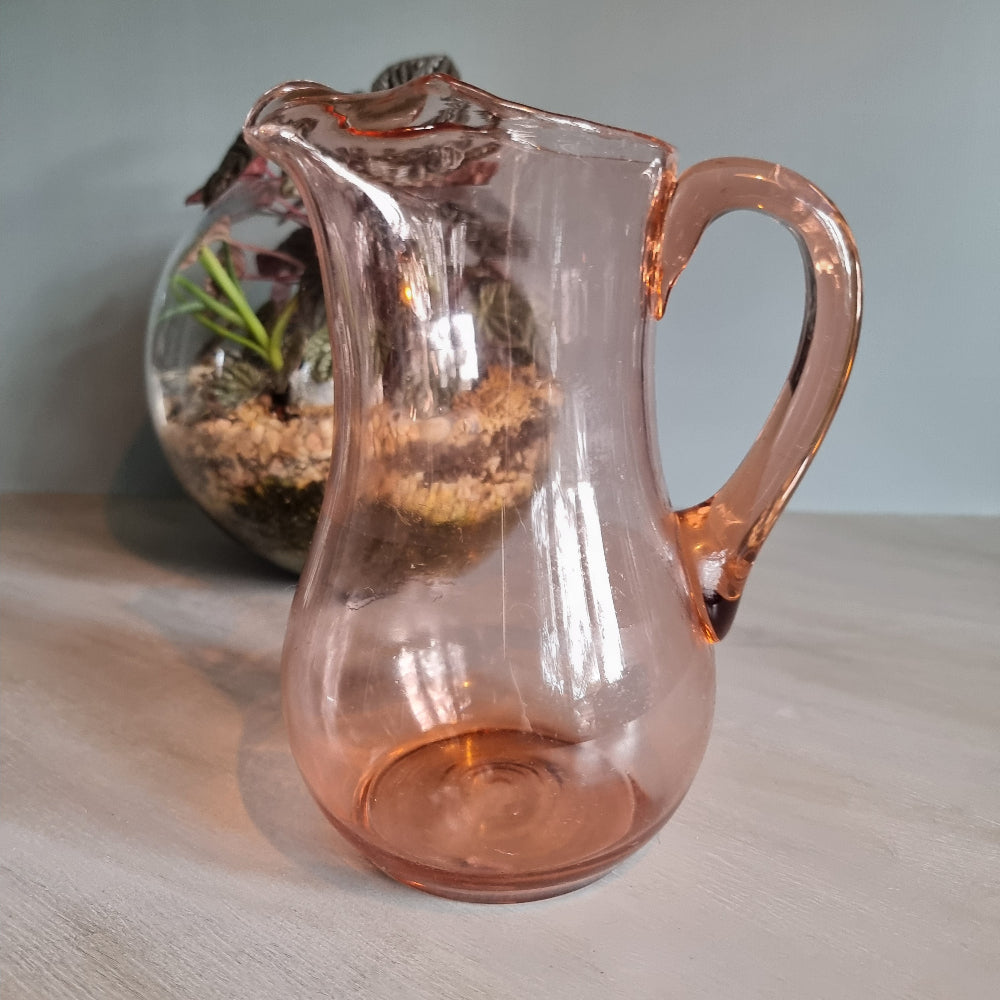 Vintage pink glass jug with curved handle and soft blush tint.
