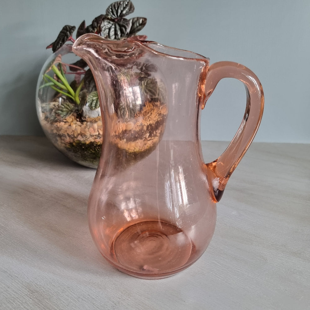 Vintage pink glass jug with curved handle and soft blush tint.