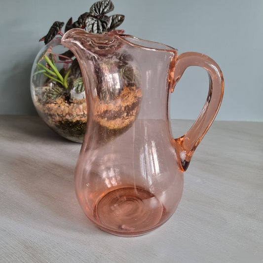 Vintage pink glass jug with curved handle and soft blush tint.