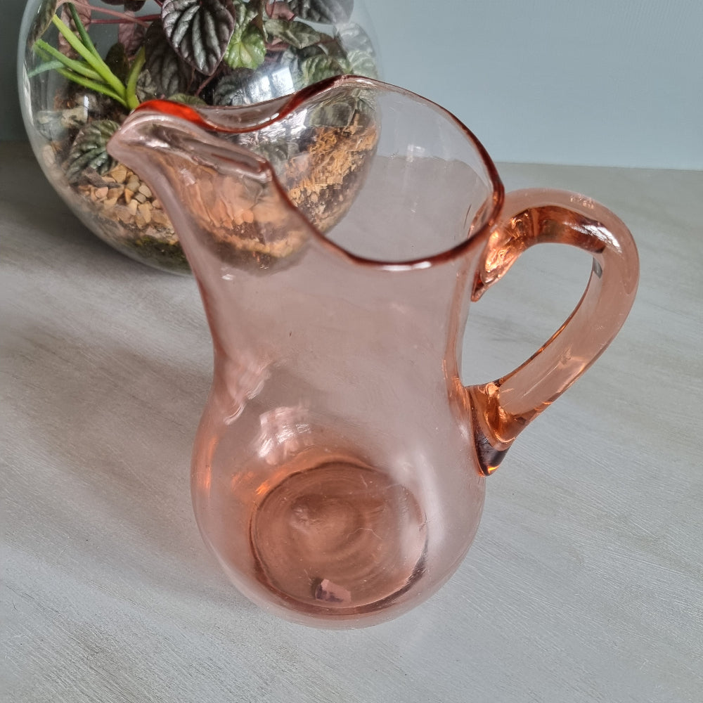 Vintage pink glass jug with curved handle and soft blush tint.