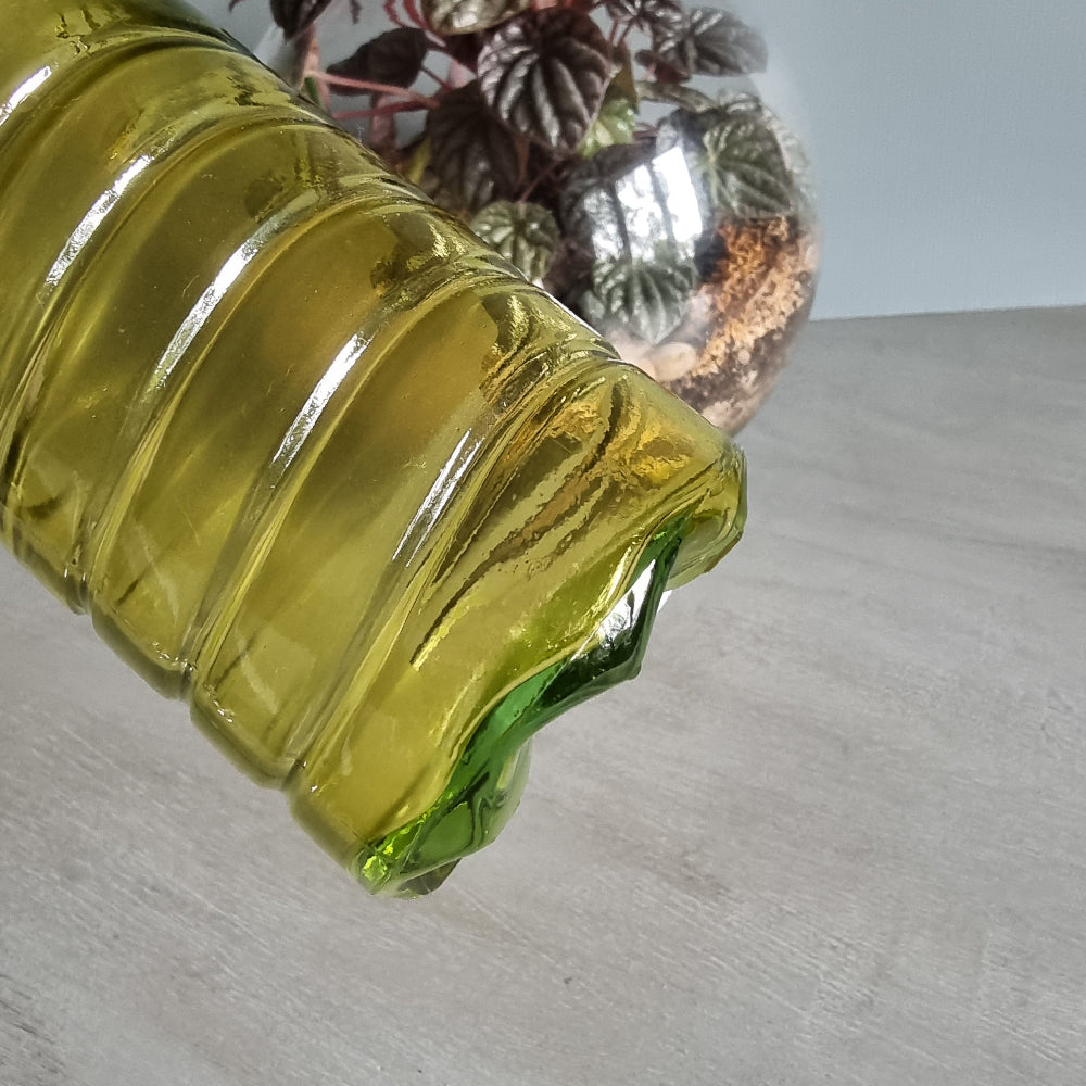 Vintage yellow-green ribbed glass bottle with small handles and retro charm.