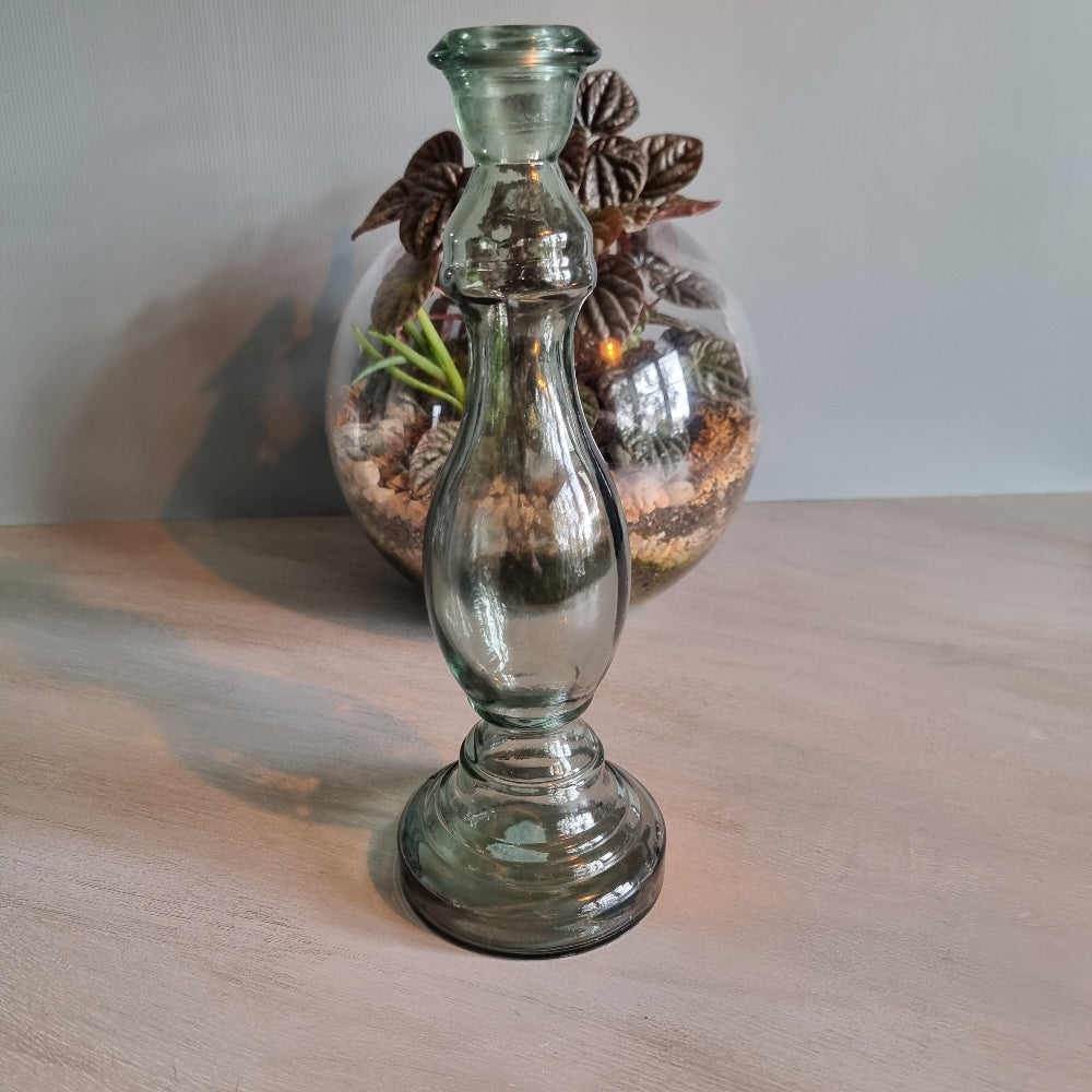 Vintage green-grey glass candlestick holder with curving shape and translucent tone.