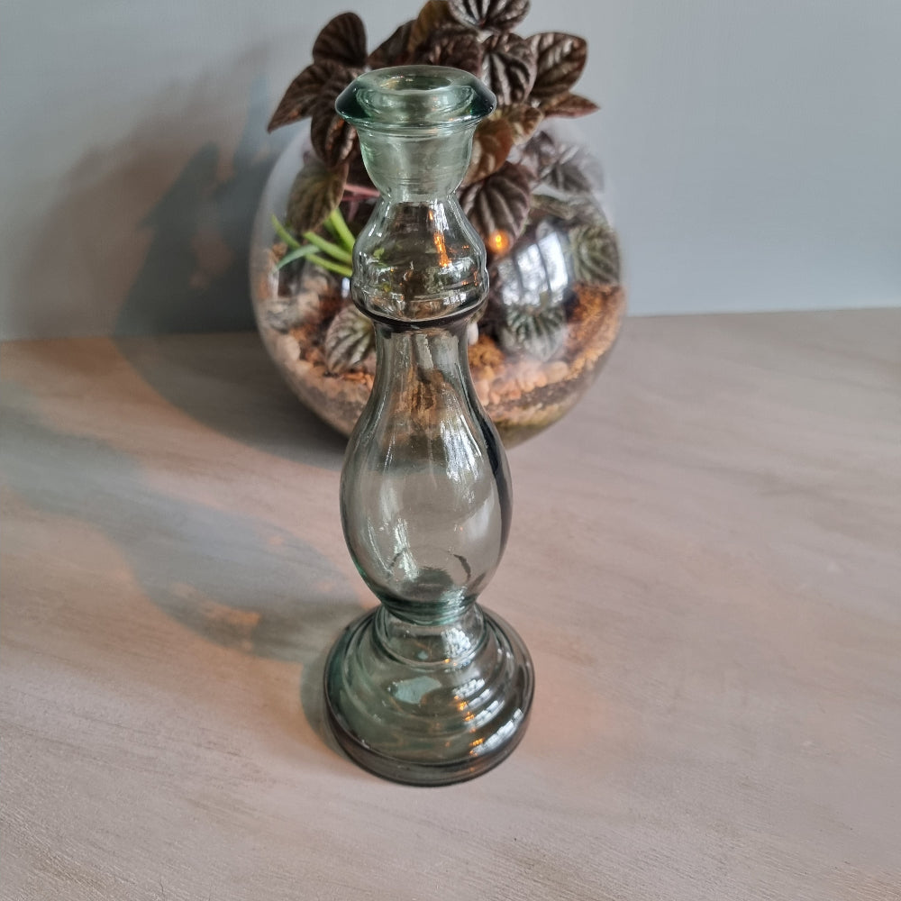 Vintage green-grey glass candlestick holder with curving shape and translucent tone.