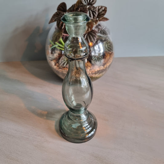 Vintage green-grey glass candlestick holder with curving shape and translucent tone.