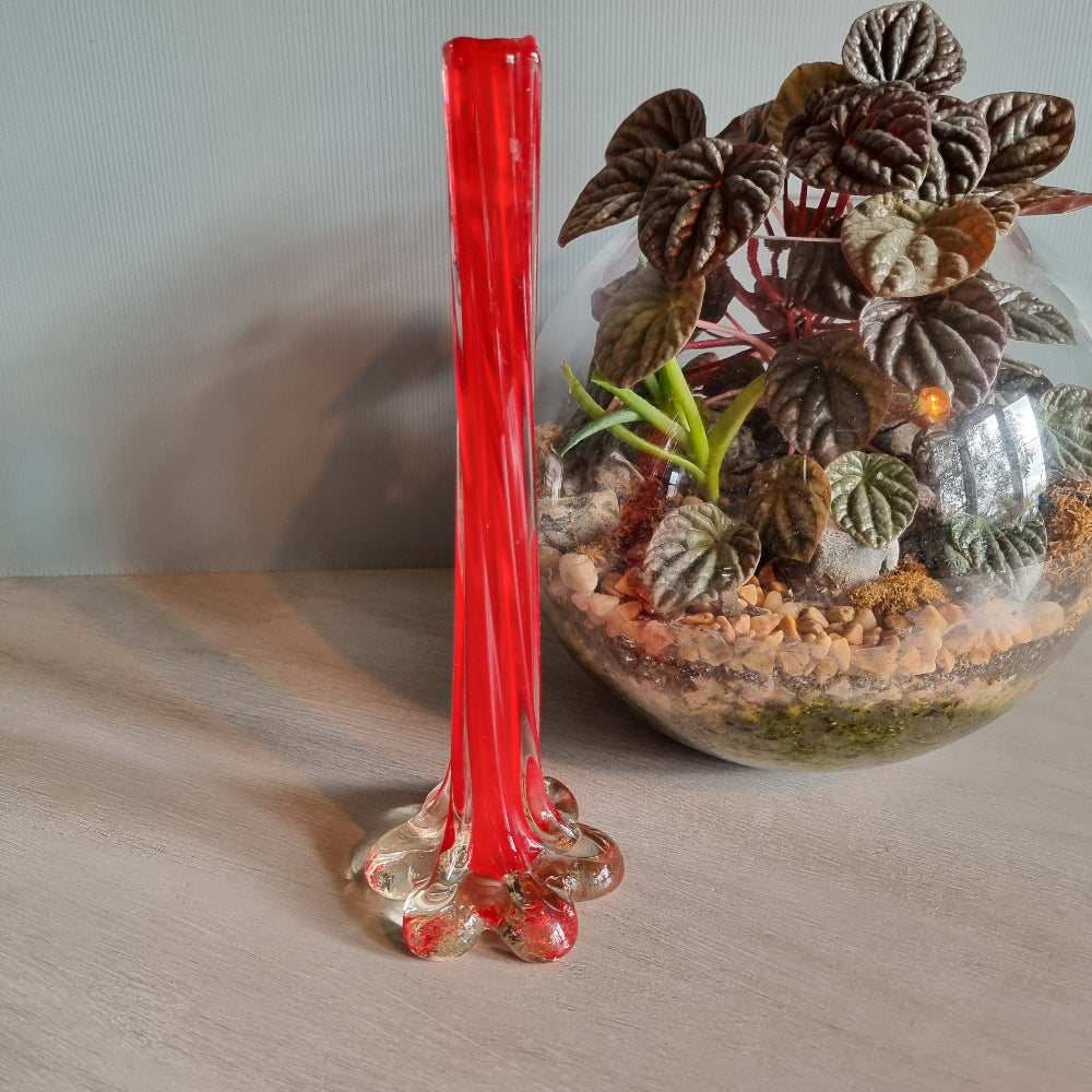Vintage red art glass bud vase with clear base and pulled-stem design.