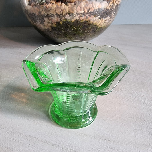 Vintage green Depression glass fluted vase with scalloped rim and bright glow.