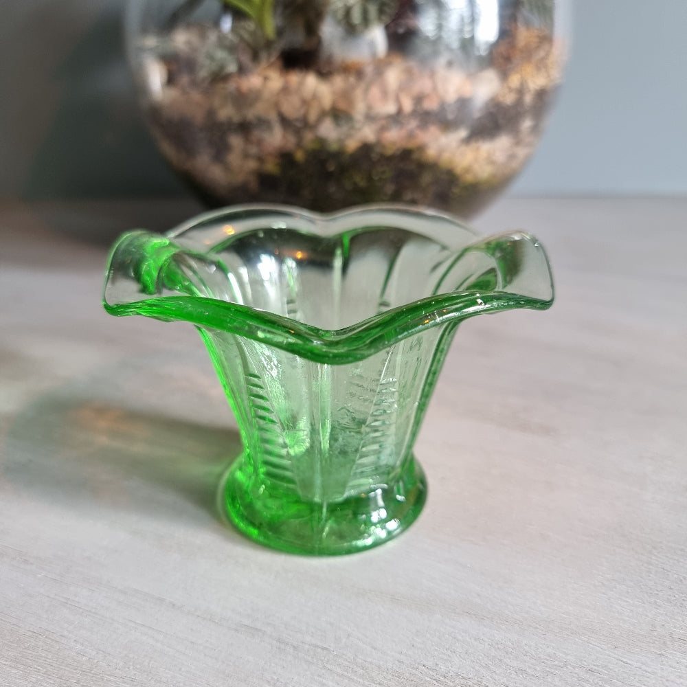 Vintage green Depression glass fluted vase with scalloped rim and bright glow.
