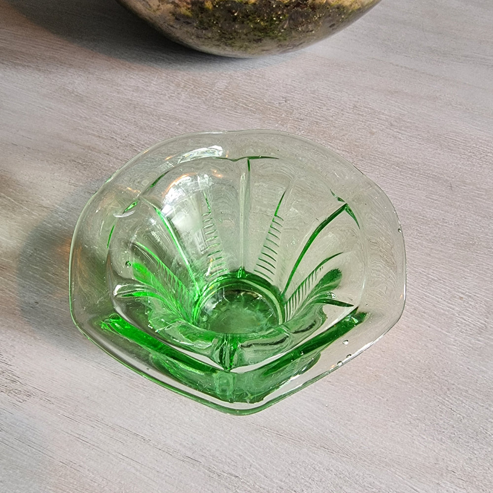 Vintage green Depression glass fluted vase with scalloped rim and bright glow.