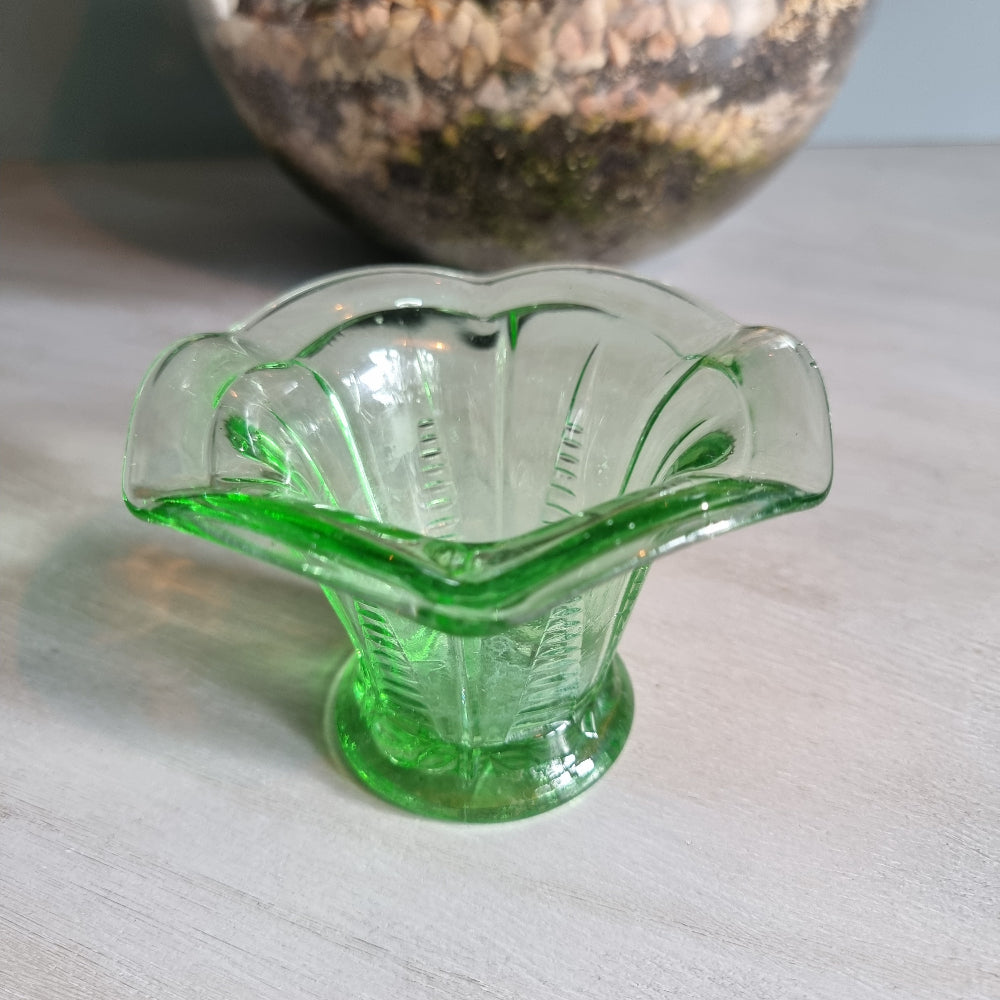 Vintage green Depression glass fluted vase with scalloped rim and bright glow.