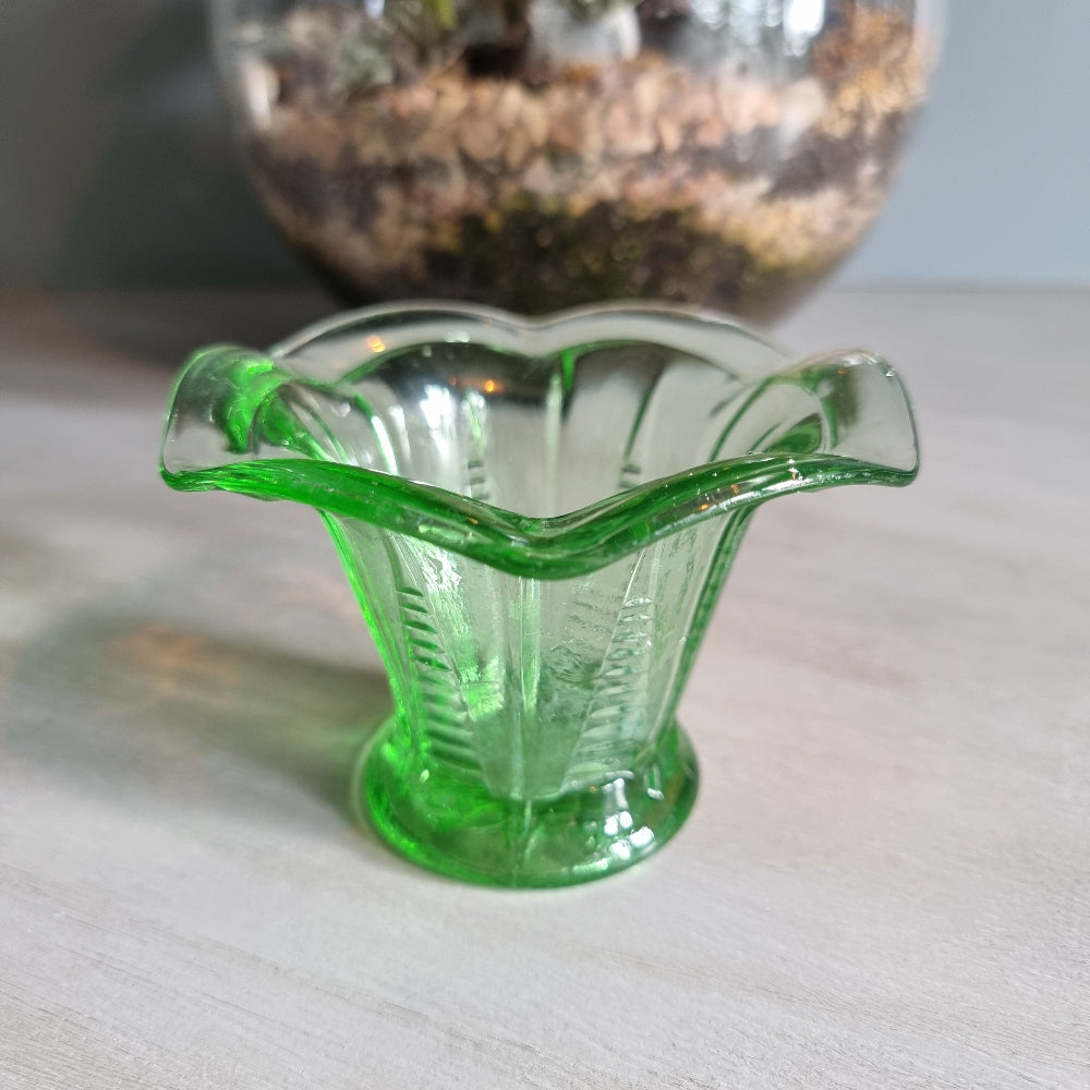 Vintage green Depression glass fluted vase with scalloped rim and bright glow.