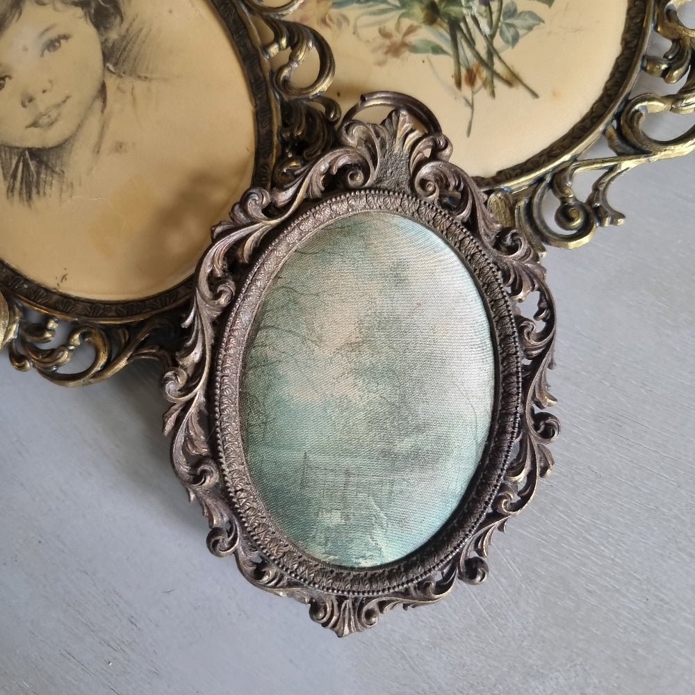 Set of vintage Italian brass oval frames with ornate scrollwork and silk prints