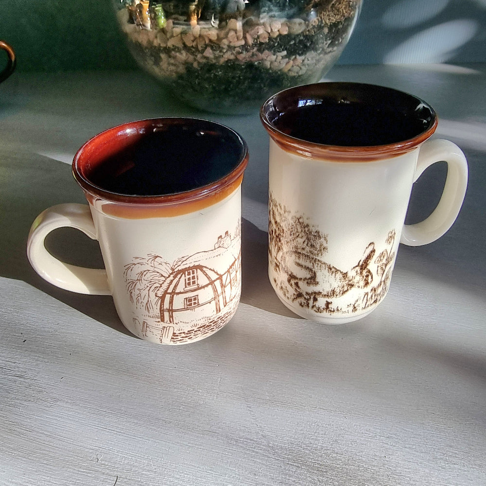 Two vintage English mugs by Bilton and Churchill with rabbit and cottage countryside illustrations on a tabletop.