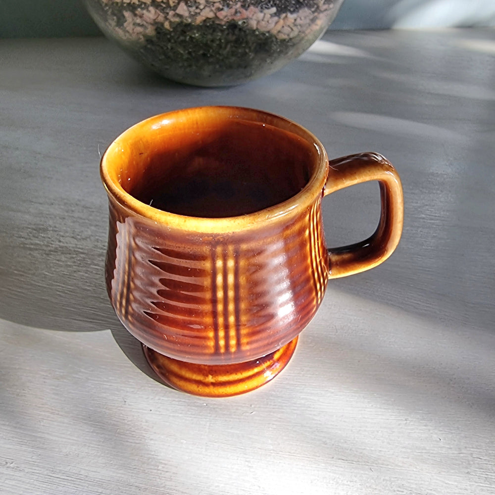 Vintage brown pedestal mug with ribbed sides and raised base, retro stoneware coffee mug.