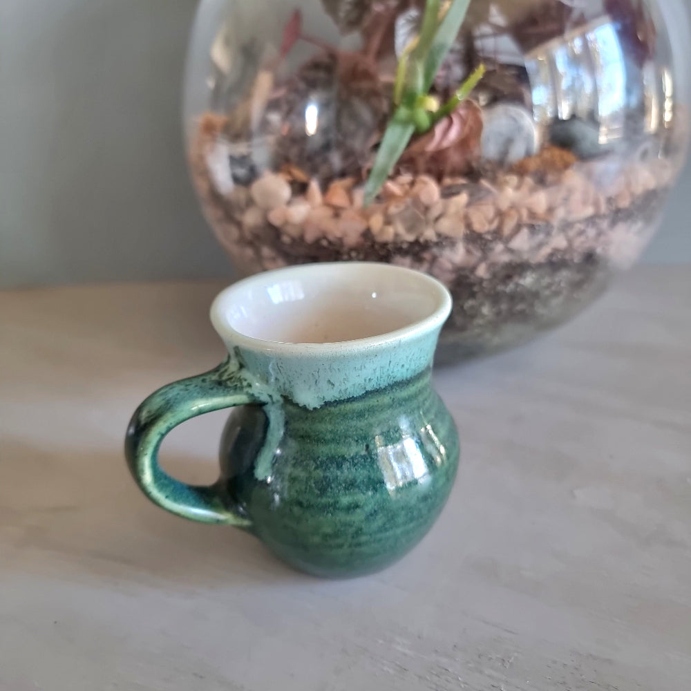 Vintage green studio pottery mug with cream rim and handle