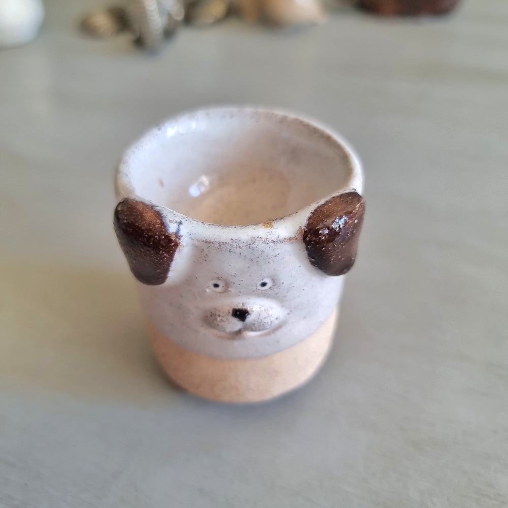 Handmade stoneware egg cup shaped like a dog face with speckled glaze