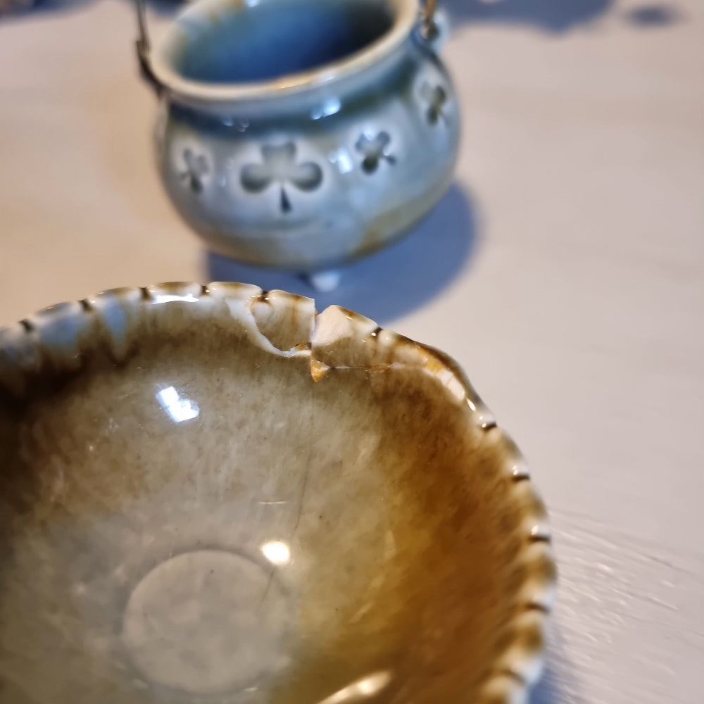 Trio of vintage Wade shamrock dishes in grey-blue glaze with honey brown highlights, including a footed dish, a pierced pot with wire handle, and a clover-shaped dish