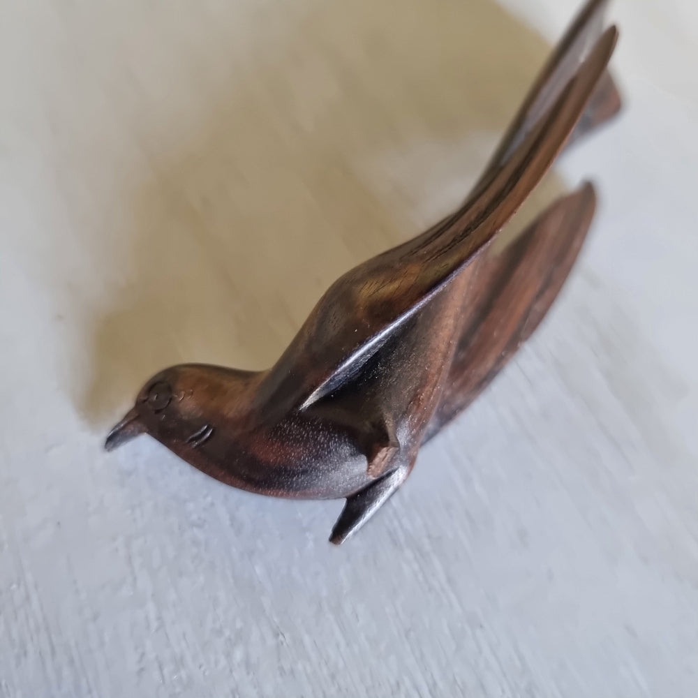 Carved wooden bird ornament with detailed feather carving