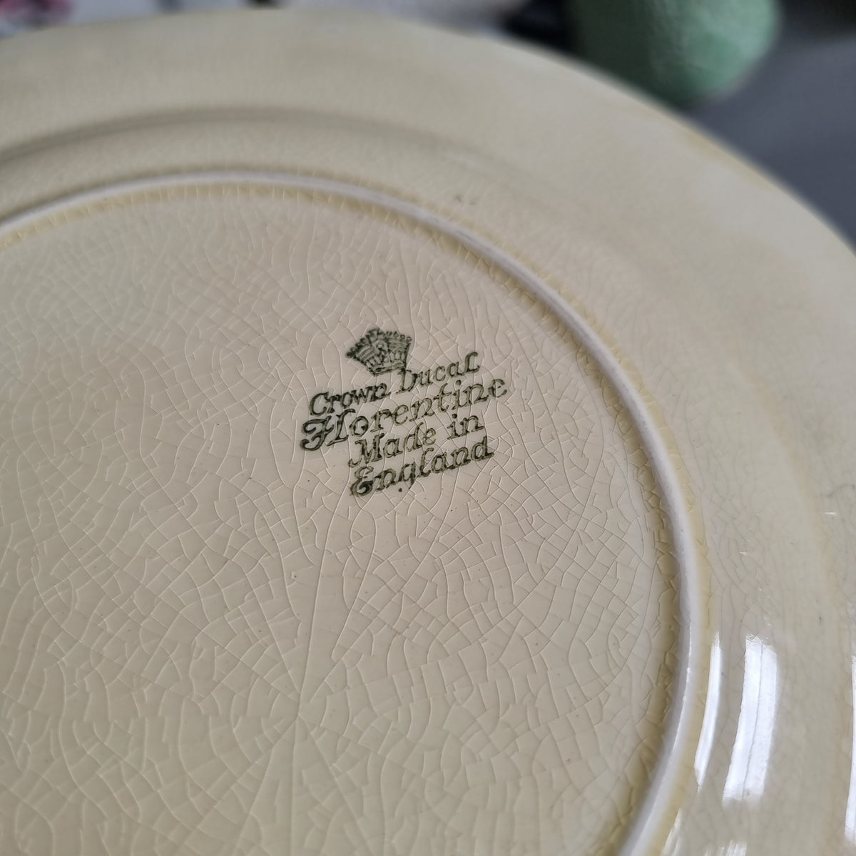Vintage Crown Ducal Florentine plate showing a bar scene with men in hats and the words What's yourn, gents, in a moulded cream border