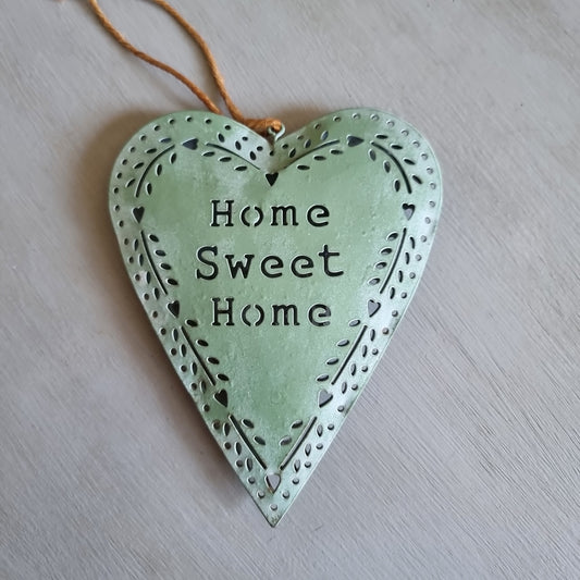 Sage green metal heart with Home Sweet Home cut out in the centre and a punched heart and leaf border, hanging from twine
