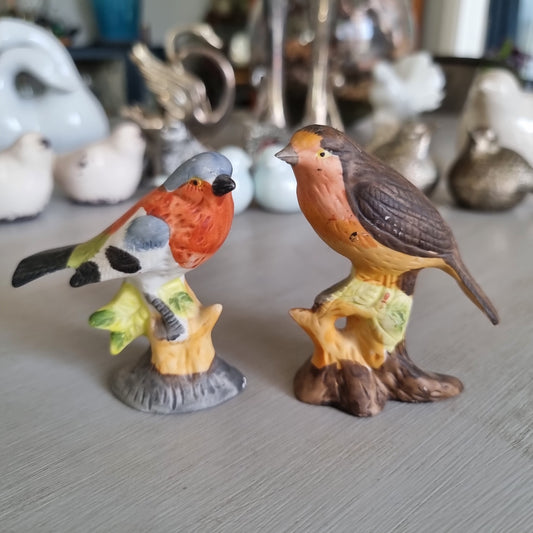 Hand-painted porcelain robin and chaffinch figurines perched on stumps