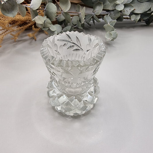 Vintage floral cut glass bud vase with etched flower pattern and faceted base.