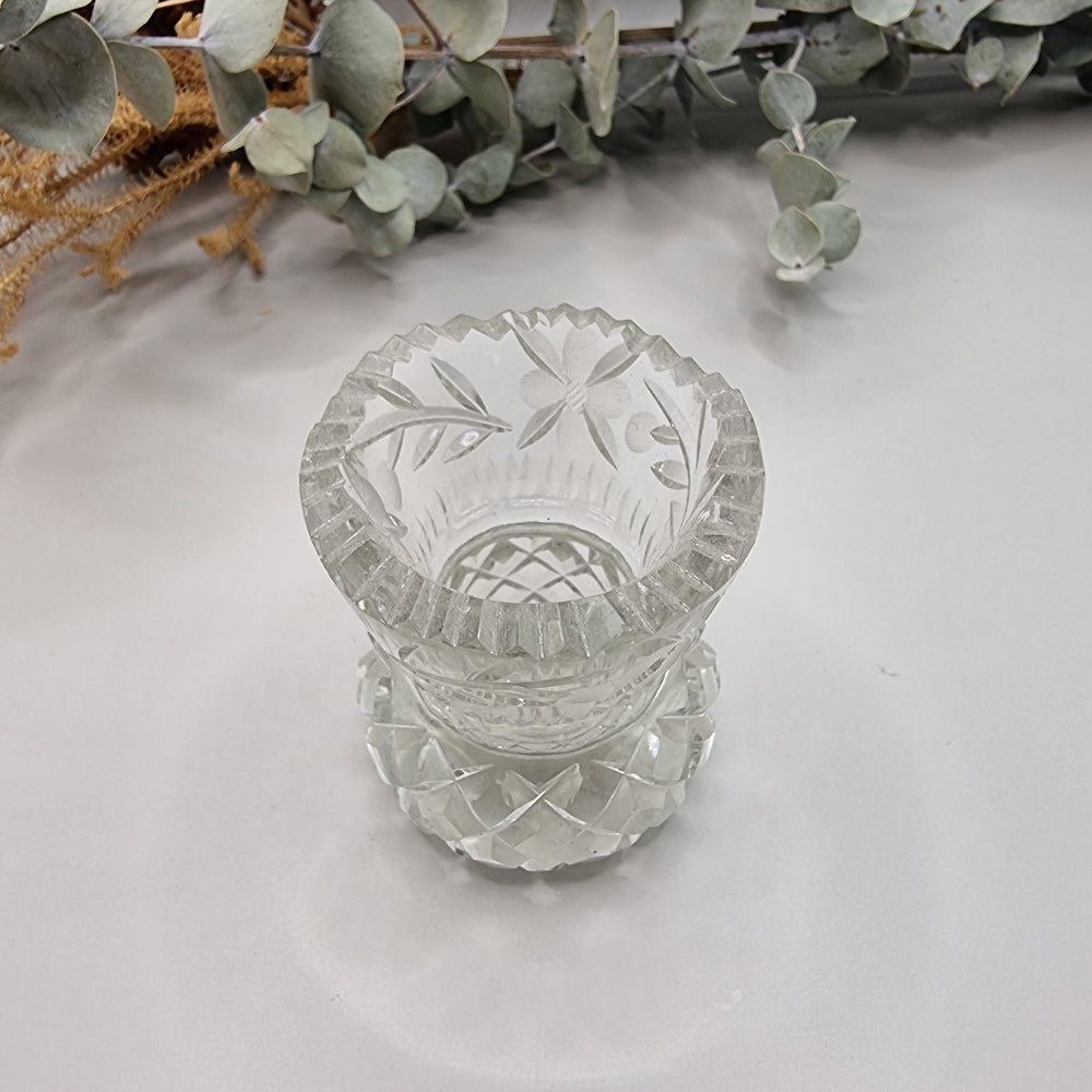 Vintage floral cut glass bud vase with etched flower pattern and faceted base.