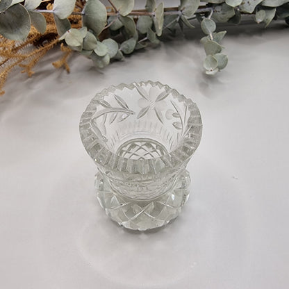 Vintage floral cut glass bud vase with etched flower pattern and faceted base.