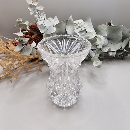 Vintage cut glass bud vase with starburst pattern and faceted base.