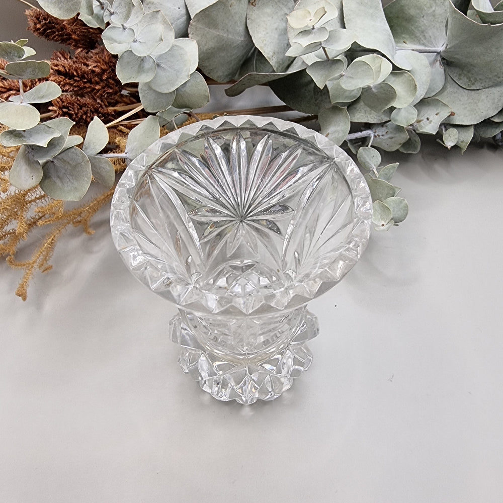 Vintage cut glass bud vase with starburst pattern and faceted base.