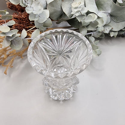 Vintage cut glass bud vase with starburst pattern and faceted base.