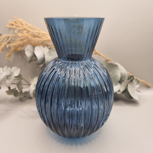 Blue ribbed glass vase with flared neck and rounded base.