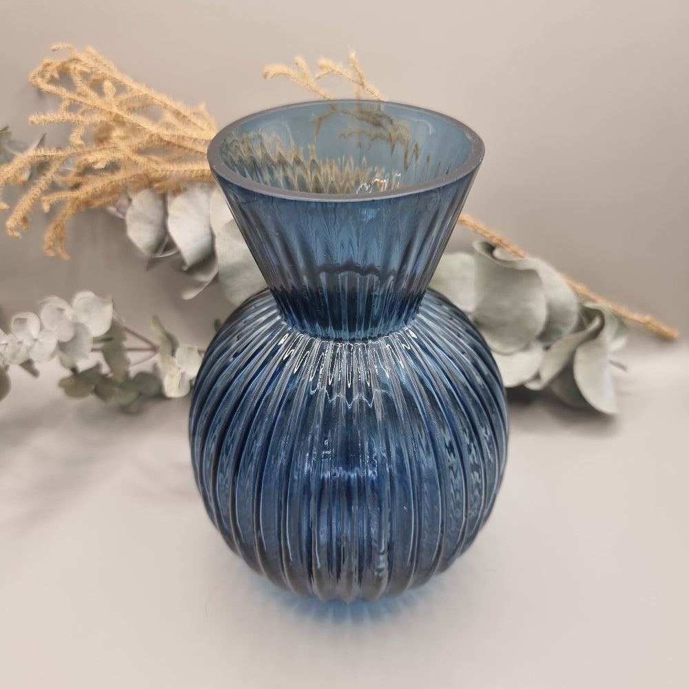 Blue ribbed glass vase with flared neck and rounded base.