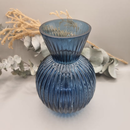 Blue ribbed glass vase with flared neck and rounded base.