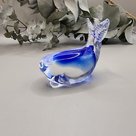 Hokitika art glass clear and blue glass whale ornament with curved tail and smooth finish.
