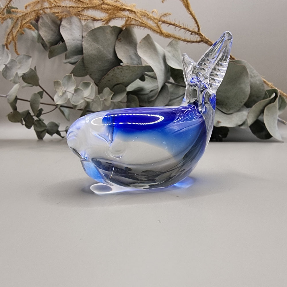 Hokitika art glass clear and blue glass whale ornament with curved tail and smooth finish.