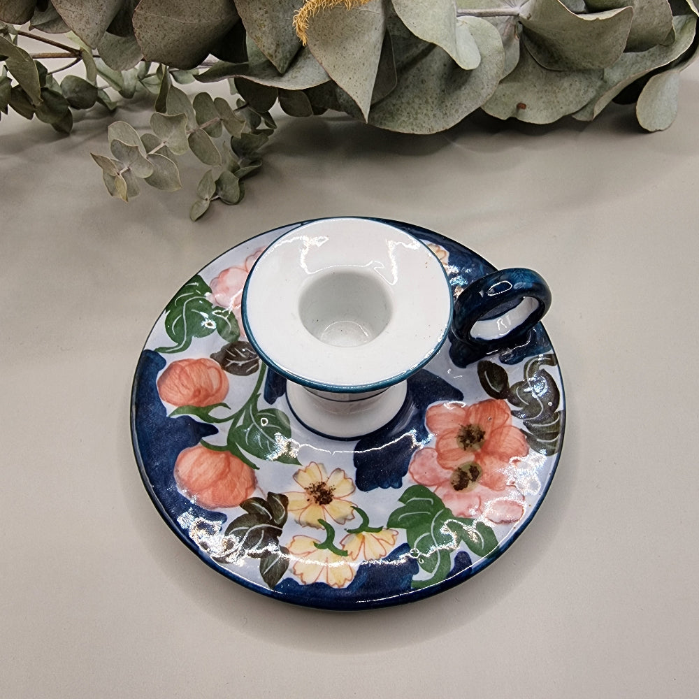 Vintage hand-painted ceramic chamberstick candle holder with pink rose and floral design on navy blue and white glaze