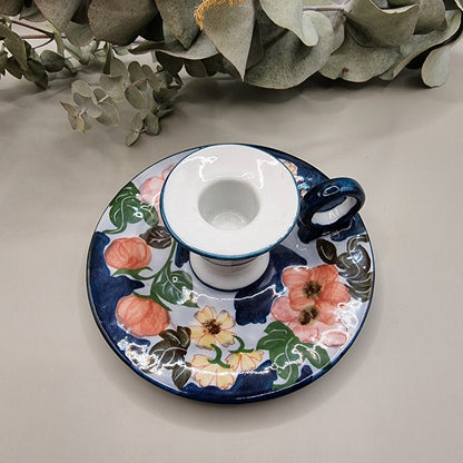 Vintage hand-painted ceramic chamberstick candle holder with pink rose and floral design on navy blue and white glaze