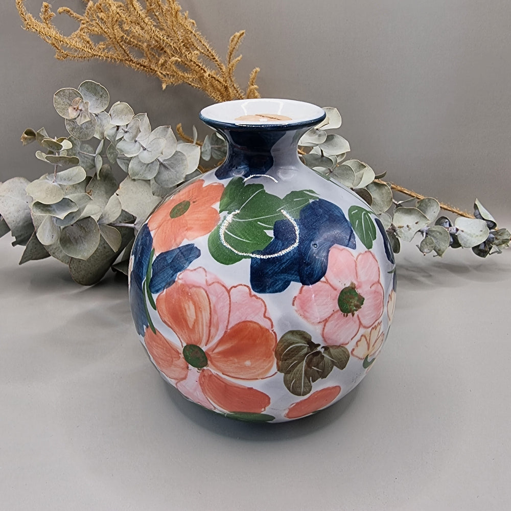 Vintage hand-painted ceramic round globe vase with large bold pink and coral floral design on white glaze, narrow navy rimmed neck