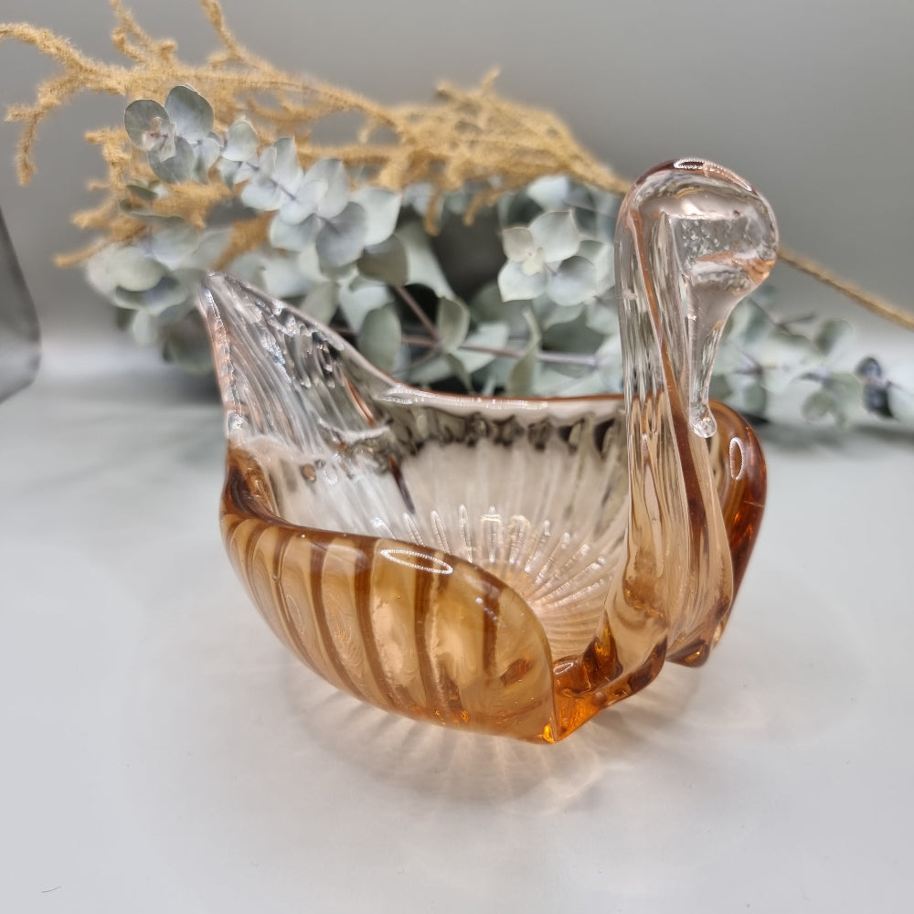 Amber glass swan-shaped trinket dish with ribbed wings and elegant curved neck.