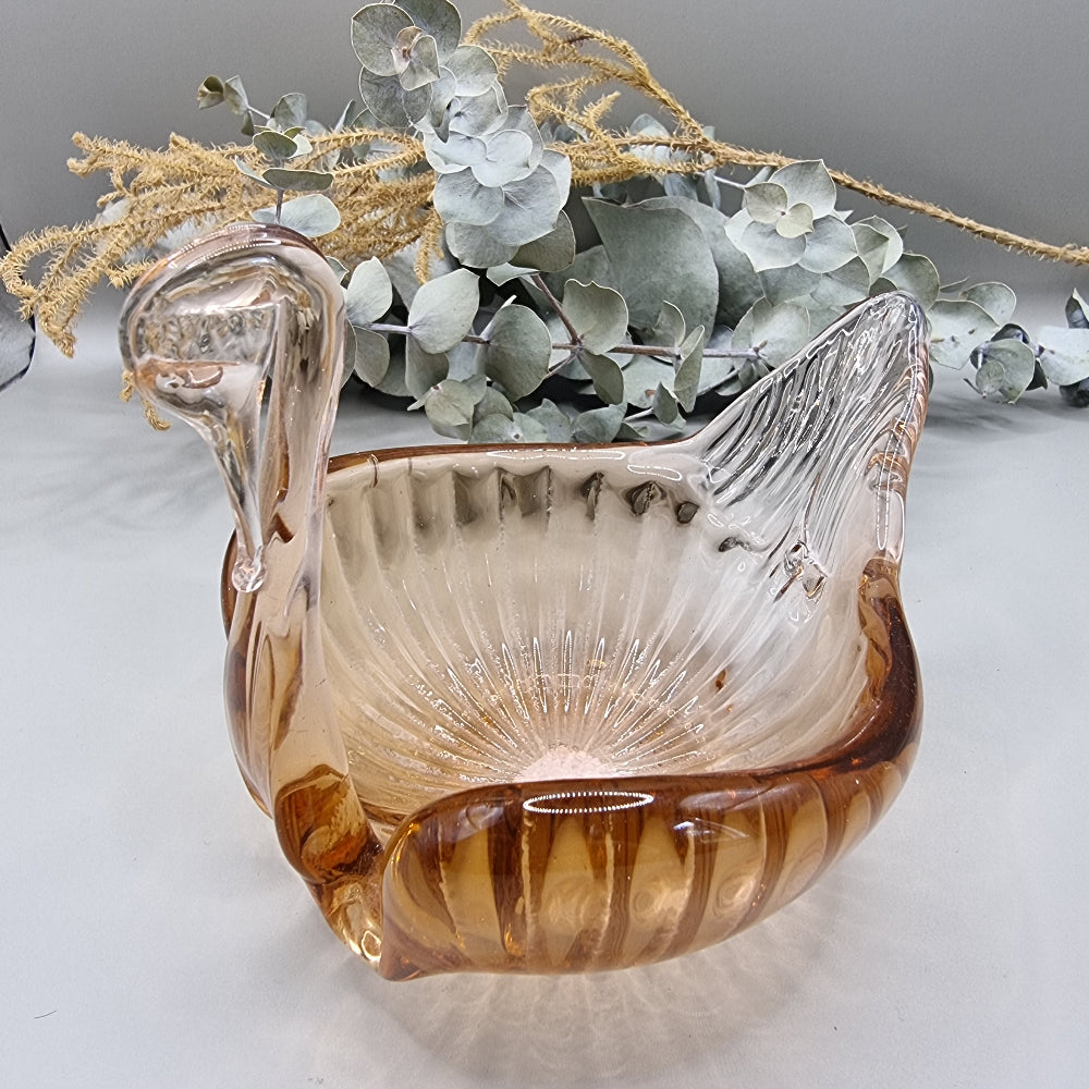 Amber glass swan-shaped trinket dish with ribbed wings and elegant curved neck.