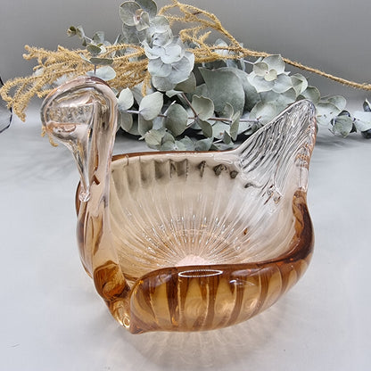 Amber glass swan-shaped trinket dish with ribbed wings and elegant curved neck.