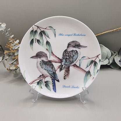 Decorative plate with two Blue-Winged Kookaburras on branches, with botanical detail.