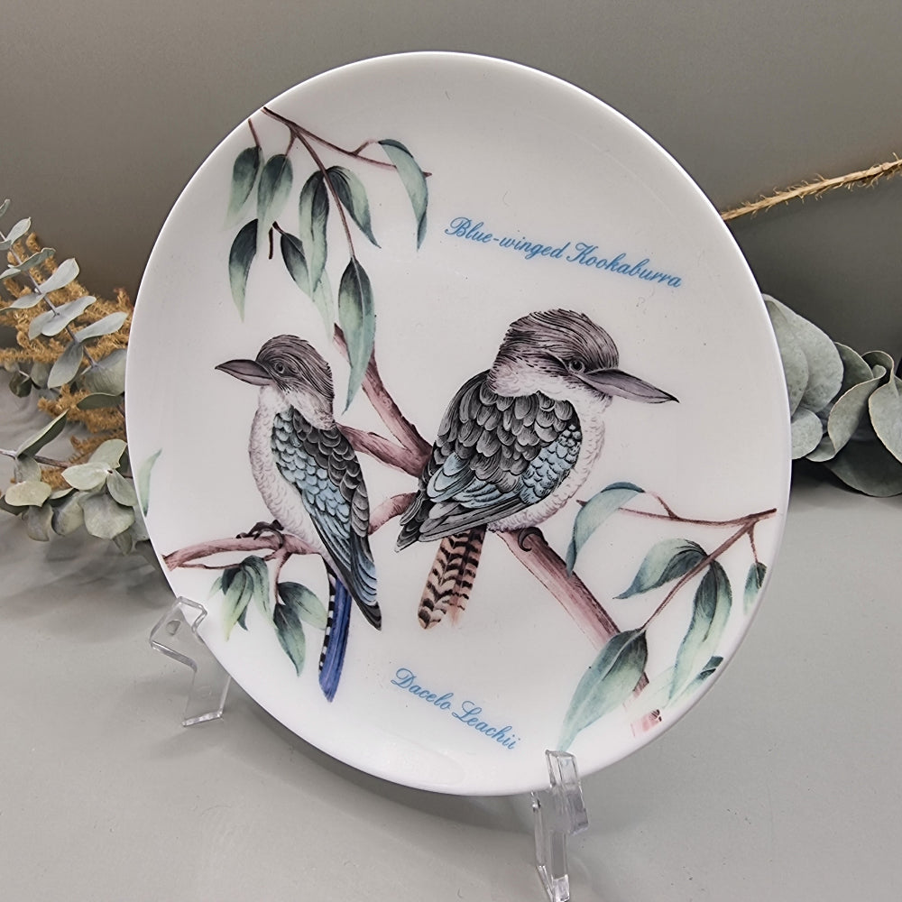 Decorative plate with two Blue-Winged Kookaburras on branches, with botanical detail.