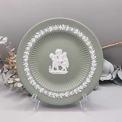 Sage green Jasperware plate with white cherub design and laurel border.